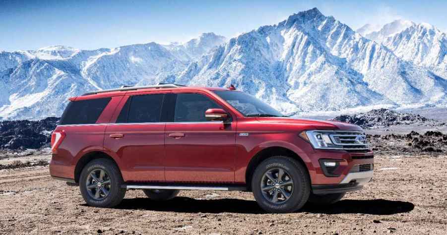 A red 2018 Ford Expedition parked in right profile view in front of snowy mountains