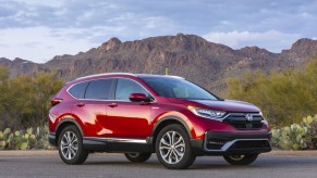 A red 2020 Honda CR-V Hybrid parked in right front angle view in front of a mountain