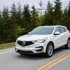 A white 2021 Acura RDX driving in left front angle view