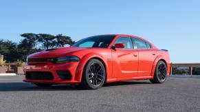 A red 2021 Dodge Charger Scat Pack Widebody parked on pavement in left front angle view