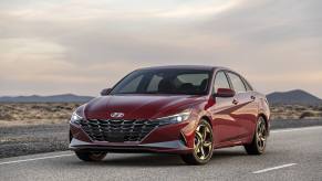 A red 2021 Hyundai Elantra parked on a natruesque highway at dawn