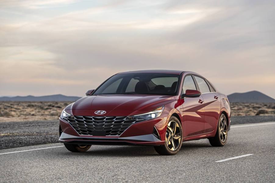 A red 2021 Hyundai Elantra parked on a natruesque highway at dawn