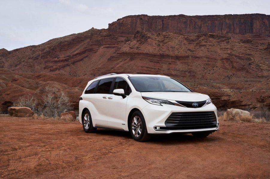 A white 2021 Toyota Sienna parked in right front angle view in a rocky, dusty clay desert environment