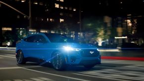 A Ford Mustang Mach-E GT, one of the Blue Oval's EV sales performers, drives in a city.