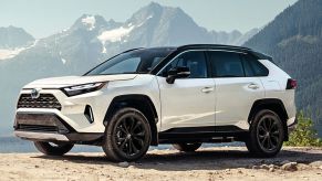 White Toyota RAV4 parked with mountains in the background.