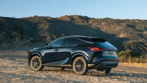 A dark 2025 Lexus RX 350 parked outside in left rear angle view