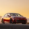 A red 2025 Toyota Camry parked in right front angle view during sunset