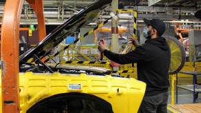 A worker builds American muscle cars like the Dodge Challenger at the Brampton Assembly Plant in Canada.