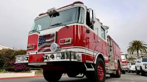 A fire truck, an engine, shows off its bright red aesthetic.