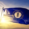 Blue flag that says "commonwealth of Kentucky" with the sun in the background.