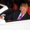 Donald Trump sitting in a white Chevrolet Camaro convertible with a red interior.