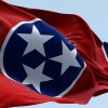 Bright red Tennessee flag with three white stars on a blue circle.