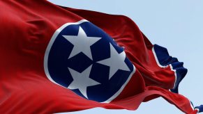 Bright red Tennessee flag with three white stars on a blue circle.