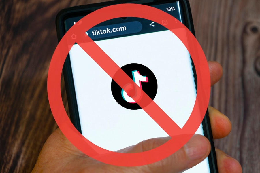 A TikTok app loading screen on a cellphone with a red slash super-imposed on it.