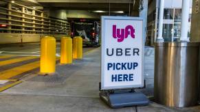 Sign with Uber and Lyft logo at airport marking the ride share driver pickup zone.