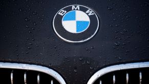 A BMW logo above the grille accentuated by rain on the black hood