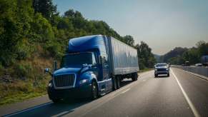 A pickup truck passing a semi-truck on the freeway