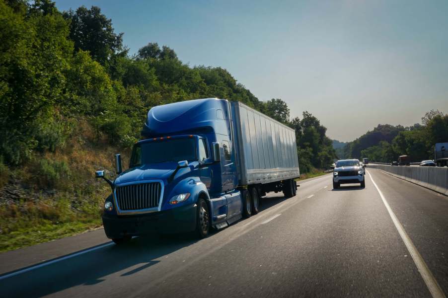 A pickup truck passing a semi-truck on the freeway