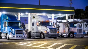 Semi trucks at night, parked in a gas station