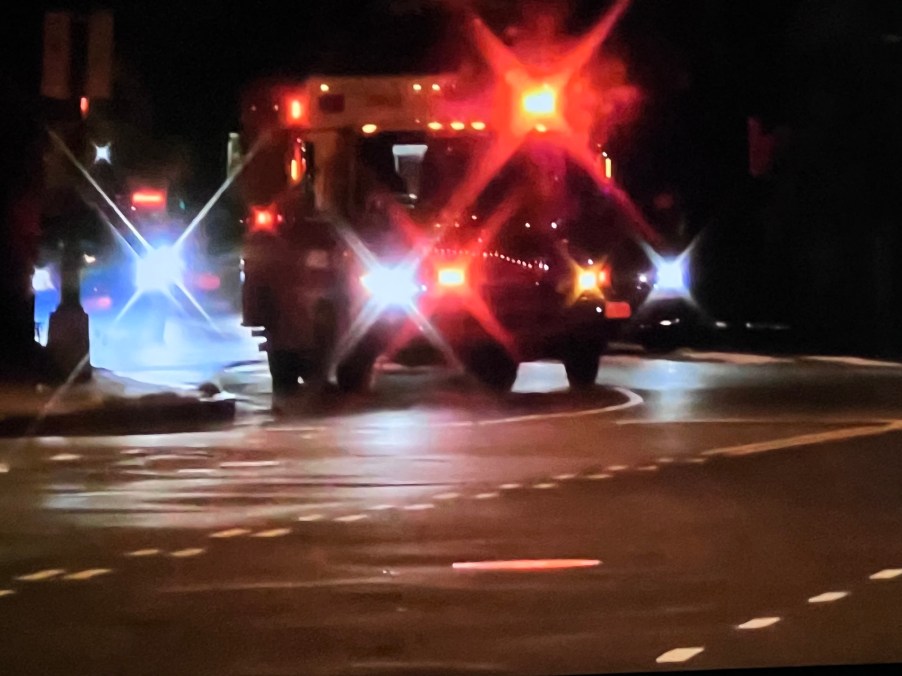 Ambulance on the highway at night, its red lights flashing.