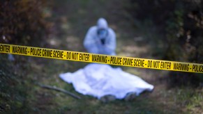 A cop investigating a murder at a crime scene