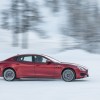 A red Maserati Quattroporte driving in the snow, the car is one of the fastest-depreciating cars on the market