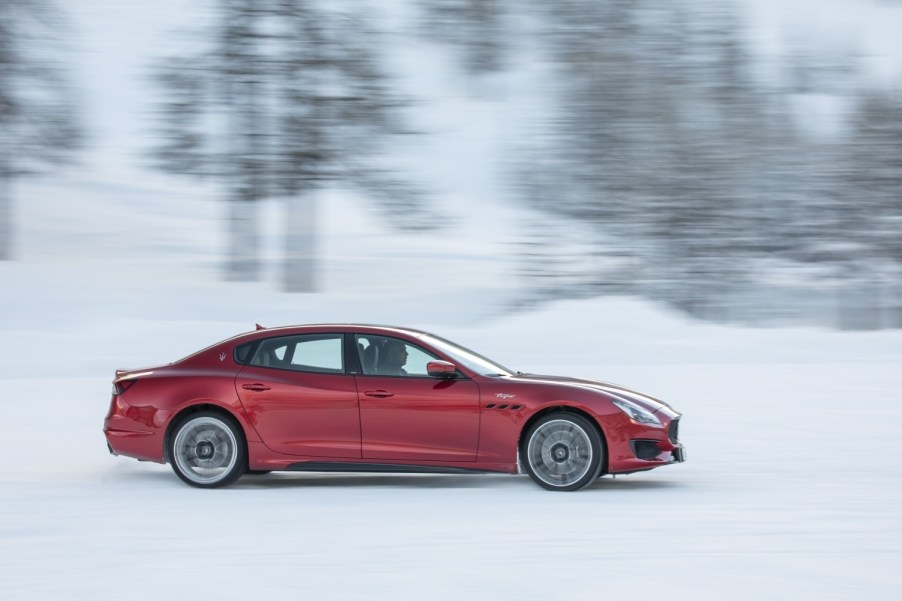 A red Maserati Quattroporte driving in the snow, the car is one of the fastest-depreciating cars on the market