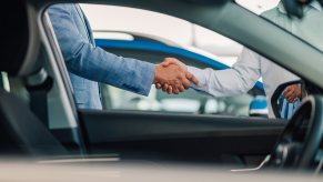 Two people shaking hands after new car purchase