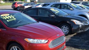 Cars sitting in a parking lot of a used car dealership