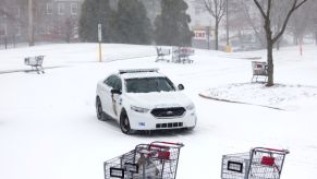 A police car driving in a snowy parking lot