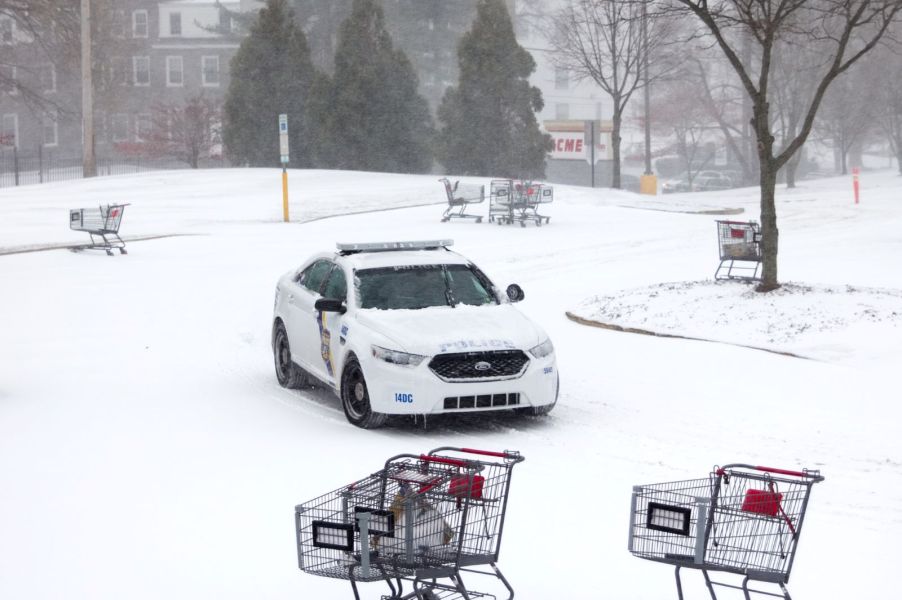 A police car driving in a snowy parking lot