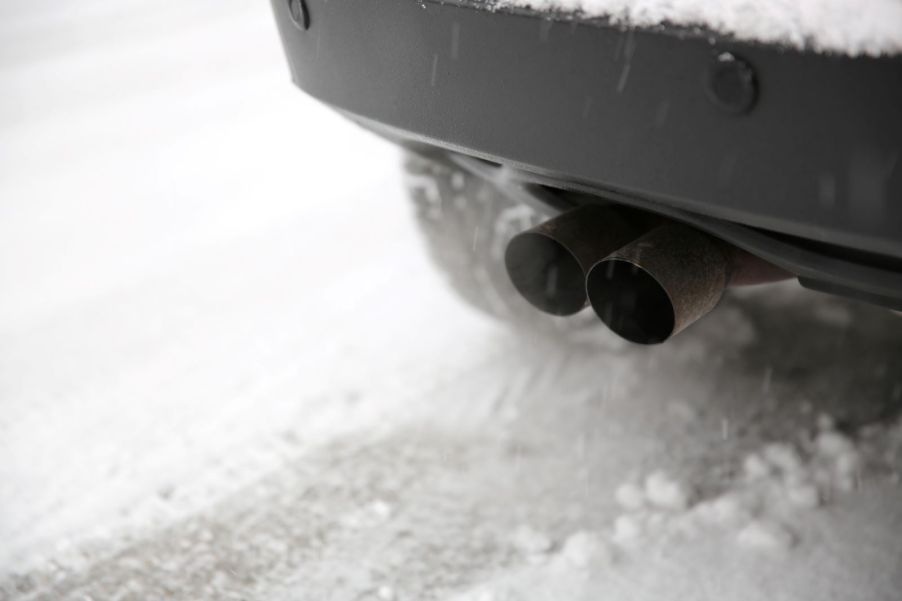 A car warming up on a cold winter's morning, with exhaust coming from the tailpipe