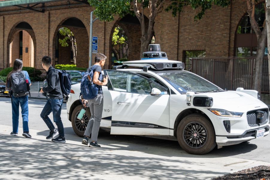 A passenger getting into a self-driving Waymo car in San Francisco, California