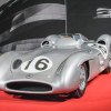 Silver Mercedes-Benz race car on a red carpet at a classic vehicle auction.