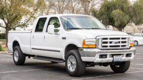 A white 2000 Ford F-250 Super Duty truck parked in right front angle view