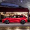 A bright-red Ford Escape shows off its side profile next to a business.