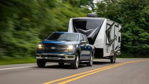 A Ford F-150 XLT, a direct competitor for the RAM 1500 and Silverado, pulls an RV trailer.