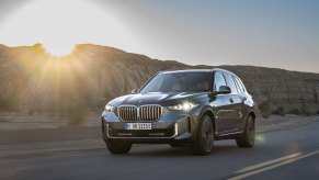 2024 BMW X5 driving at sunset