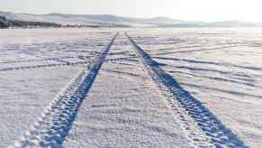 Tire tracks through snow from an AWD SUV winter drag race test.