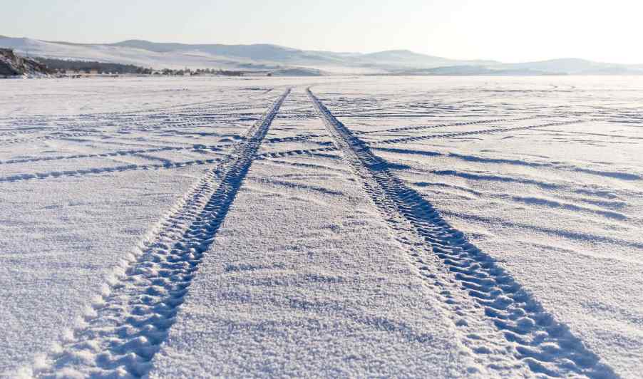 Tire tracks through snow from an AWD SUV winter drag race test.