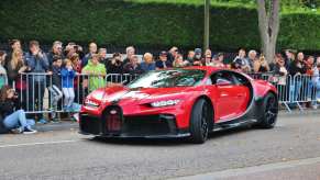 Red Bugatti Chiron hypersport in Molsheim France, a crowd visible in the background.