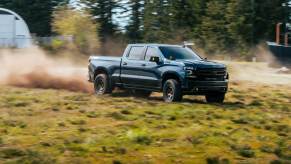 A Chevrolet Silverado pickup truck kicks up dirt and dust.