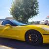 Bright yellow Corvette parked at a gas station.