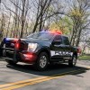 A police truck on the road with its lights on