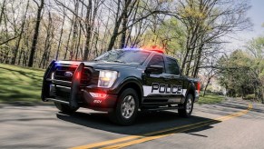 A police truck on the road with its lights on