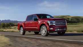 A red 2025 Ford F-150 driving on the road