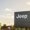 Jeep logo high on the wall of a dealership.