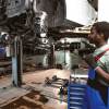 A mechanic works on open recalls in a shop.