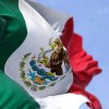 The national flag of Mexico, waving in front of a blue sky.