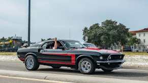 Black Mustang Mach 1 driving down the street.